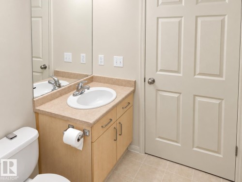 Vanity with an integrated oval sink, chrome faucet, and light-toned countertop - 507 Wiseman Lane Nw, Edmonton, AB 