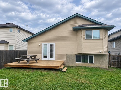 Expansive backyard featuring a wood deck, double glass-paneled doors, a bay window, and a privacy fence - 507 Wiseman Lane Nw, Edmonton, AB 