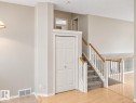 Carpeted staircase with wood handrails, wood-finish flooring, and a bi-fold door - 507 Wiseman Lane Nw, Edmonton, AB 