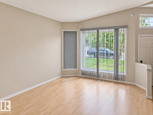 Wood-finish flooring, vaulted ceiling, vertical window blinds, and multiple windows providing natural light - 507 Wiseman Lane Nw, Edmonton, AB 