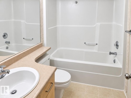 Integrated vanity with a single basin sink, chrome faucet, and expansive mirror - 507 Wiseman Lane Nw, Edmonton, AB 