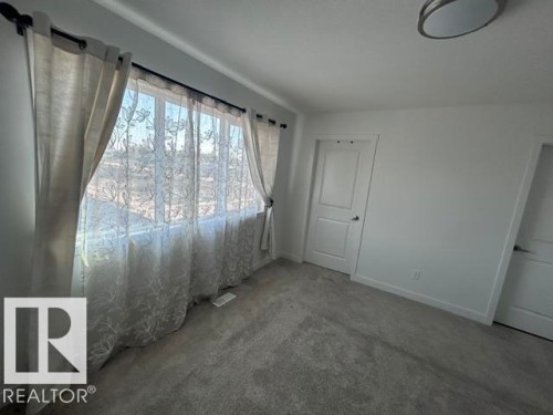 Wall-to-wall carpeting, white interior doors, and a flush mount ceiling light fixture - 20936 16 Avenue Nw, Edmonton, AB - Indoor Photo Showing Other Room