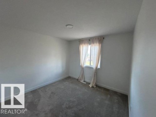 Neutral-toned walls, grey carpeting, recessed ceiling lighting, and a single window - 20936 16 Avenue Nw, Edmonton, AB - Indoor Photo Showing Other Room