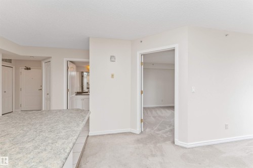 Granite-style countertop, white cabinetry, and light-toned carpeting throughout - #1101 10909 103 Av Nw, Edmonton, AB - Indoor Photo Showing Other Room