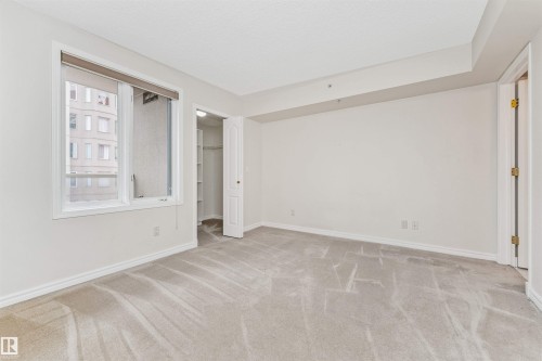 Bright room with light-toned carpeting, white walls, and a large window - #1101 10909 103 Av Nw, Edmonton, AB - Indoor Photo Showing Other Room