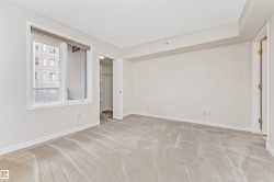 Bright room with light-toned carpeting, white walls, and a large window - 