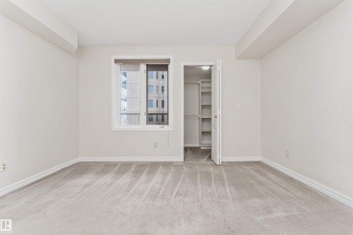 Carpeted room with a window, white walls, and a built-in closet featuring shelving - #1101 10909 103 Av Nw, Edmonton, AB - Indoor Photo Showing Other Room
