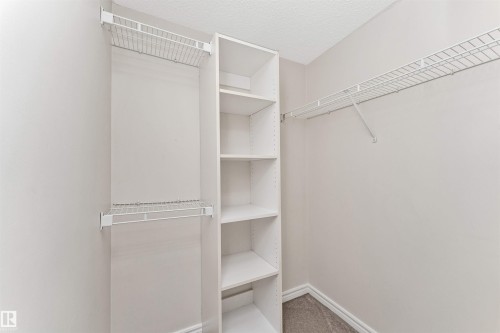 Walk-in closet featuring built-in shelving units and wire rack storage - #1101 10909 103 Av Nw, Edmonton, AB - Indoor With Storage