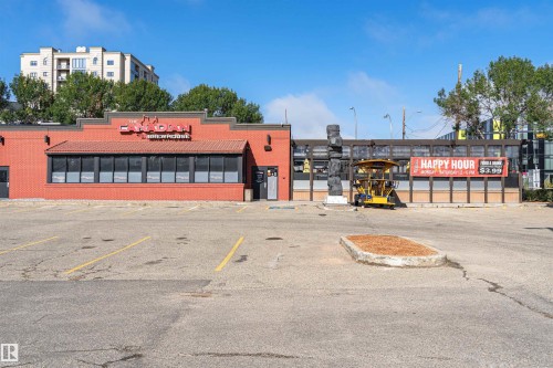 Red brick exterior with commercial storefront windows and a gabled awning - #1101 10909 103 Av Nw, Edmonton, AB - Outdoor