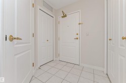 White panel doors, gold-finish hardware, tile flooring, light neutral wall color, and a functional overhead vent - 