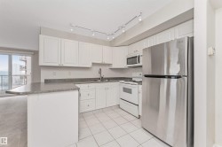Kitchen featuring white cabinetry, gray countertops, stainless steel refrigerator, white range, and white tiled flooring - 