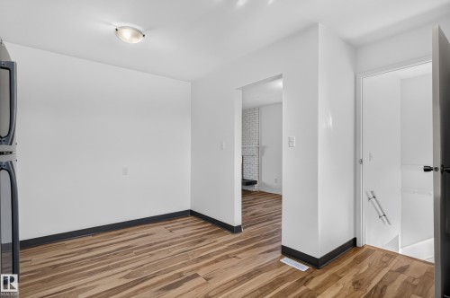 Wood-finish flooring, white painted walls, and a flush mount ceiling light - 13903 87 Street Nw, Edmonton, AB - Indoor Photo Showing Other Room