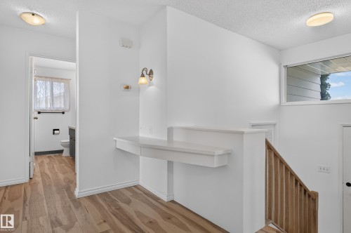 Wood-finish flooring throughout, a built-in wall shelf, flush-mount ceiling lighting, and a transom window - 13903 87 Street Nw, Edmonton, AB - Indoor Photo Showing Other Room