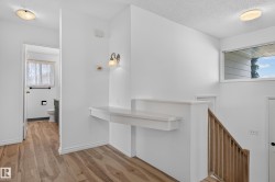 Wood-finish flooring throughout, a built-in wall shelf, flush-mount ceiling lighting, and a transom window - 