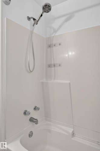 Bathtub with integrated shower surround, chrome fixtures, and handheld showerhead - 13903 87 Street Nw, Edmonton, AB - Indoor Photo Showing Bathroom