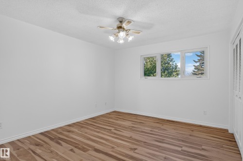Wood-finish flooring, white walls, triple window, and ceiling fan with integrated lighting - 13903 87 Street Nw, Edmonton, AB - Indoor Photo Showing Other Room