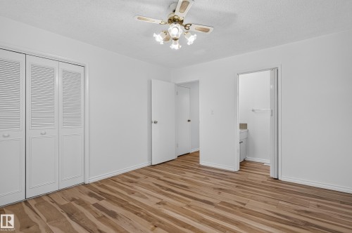 Wood-finish flooring, white walls, louvered bi-fold closet doors, ceiling fan with integrated lighting, and an adjacent room entrance - 13903 87 Street Nw, Edmonton, AB - Indoor Photo Showing Other Room