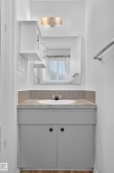 Vanity with an integrated sink, gray cabinet, and a complementing countertop - 