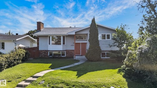 Split-level home featuring a brick chimney, bay window, and a red front door - 13903 87 Street Nw, Edmonton, AB - Outdoor With Facade