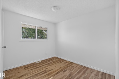 Wood-finish flooring, white walls, and a ceiling-mounted light fixture - 13903 87 Street Nw, Edmonton, AB - Indoor Photo Showing Other Room