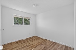 Wood-finish flooring, white walls, and a ceiling-mounted light fixture - 
