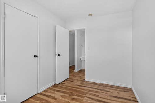 Wood-finish flooring with white baseboards and neutral wall tones - 13903 87 Street Nw, Edmonton, AB - Indoor Photo Showing Other Room