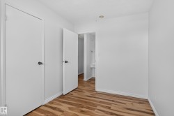 Wood-finish flooring with white baseboards and neutral wall tones - 