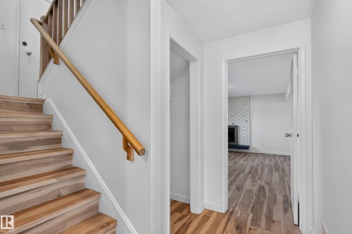 Wood-finish flooring throughout, featuring a natural wood staircase with matching handrail - 13903 87 Street Nw, Edmonton, AB - Indoor Photo Showing Other Room