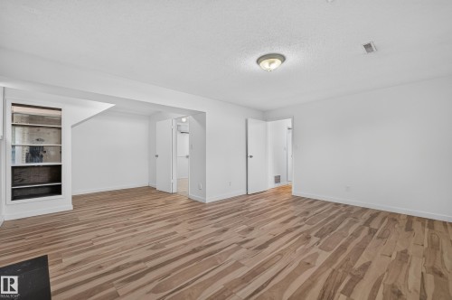 Expansive room featuring wood-finish flooring, white walls, built-in shelving, and recessed lighting - 13903 87 Street Nw, Edmonton, AB - Indoor Photo Showing Other Room
