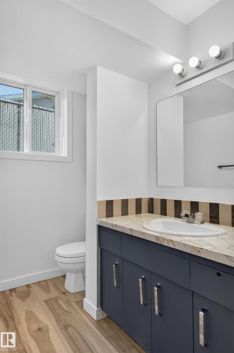 Vanity with a single basin, wood-finish flooring, and a window - 13903 87 Street Nw, Edmonton, AB - Indoor Photo Showing Bathroom