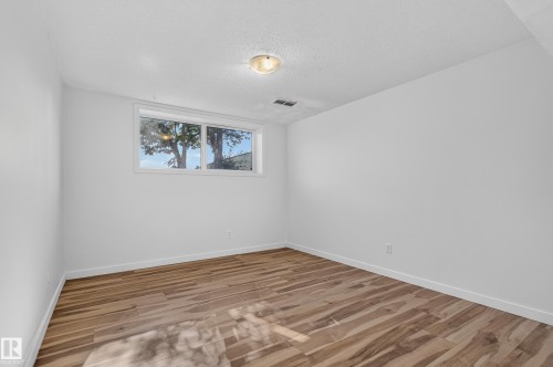 Wood-finish flooring, white walls, and a window providing natural light - 13903 87 Street Nw, Edmonton, AB - Indoor Photo Showing Other Room