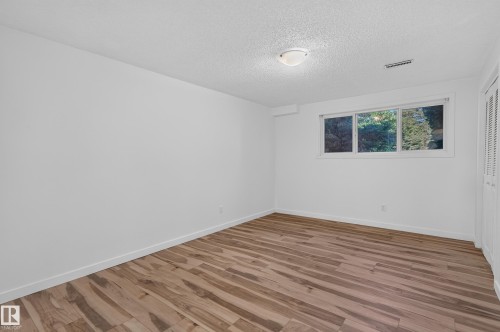 Wood-finish flooring, white walls, and a window with a white frame - 13903 87 Street Nw, Edmonton, AB - Indoor Photo Showing Other Room