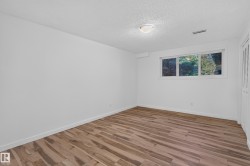 Wood-finish flooring, white walls, and a window with a white frame - 
