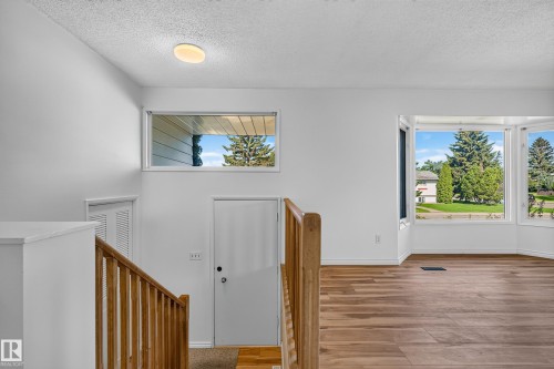 Hardwood-finish flooring, white walls, and a multi-pane bay window - 13903 87 Street Nw, Edmonton, AB - Indoor Photo Showing Other Room