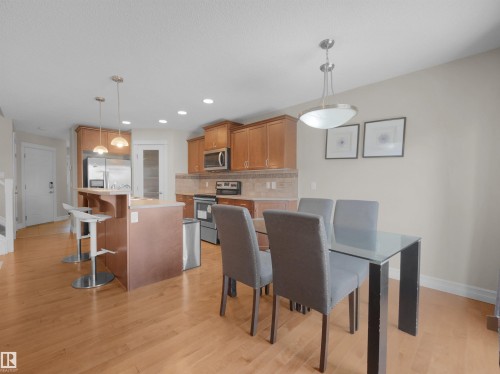 Kitchen featuring wood-finish cabinetry, stainless steel appliances, and a tile backsplash - 17127 126 Street Nw, Edmonton, AB - Indoor