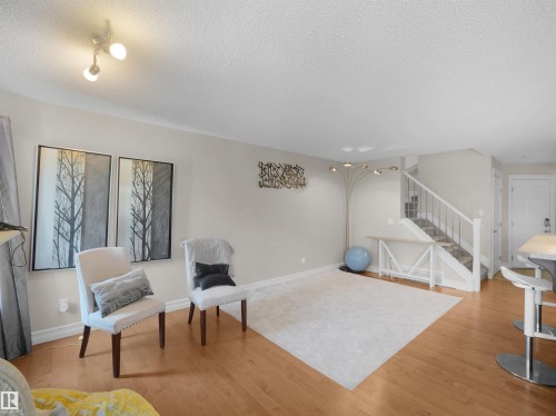 Hardwood flooring, painted walls, track lighting, staircase with white railing, and a built-in countertop - 17127 126 Street Nw, Edmonton, AB - Indoor