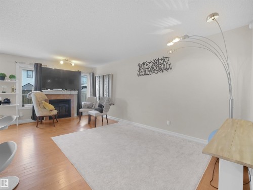 Hardwood-finish flooring, recessed lighting, and a fireplace with a stone surround - 17127 126 Street Nw, Edmonton, AB - Indoor With Fireplace