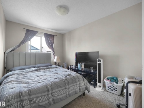 Window with a decorative curtain rod, textured ceiling, and neutral wall tones - 17127 126 Street Nw, Edmonton, AB - Indoor Photo Showing Bedroom