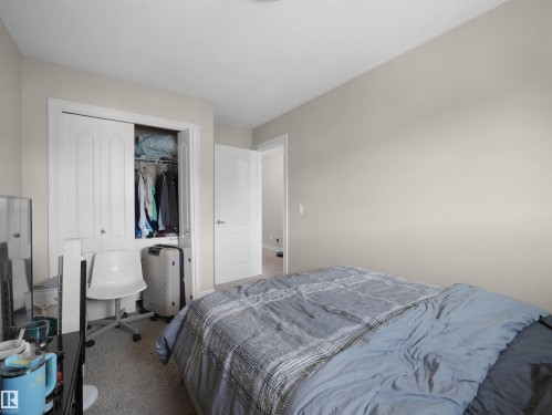 Wall-to-wall carpeting with light-toned walls, featuring a white solid core door and a bypass closet with paneled doors - 17127 126 Street Nw, Edmonton, AB - Indoor Photo Showing Bedroom