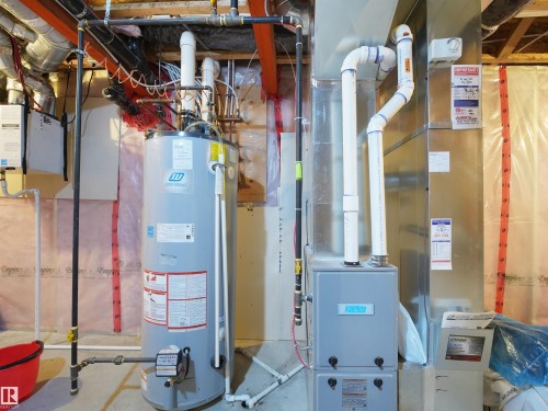 Utility room featuring a water heater, furnace, and exposed overhead piping - 17127 126 Street Nw, Edmonton, AB - Indoor Photo Showing Basement