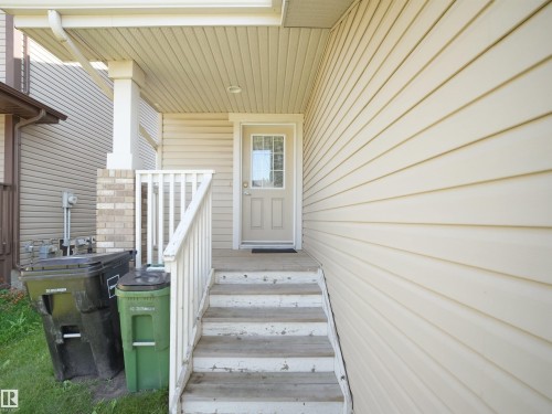 Entryway featuring wood-finish steps, white railing, and a covered porch - 17127 126 Street Nw, Edmonton, AB - Outdoor With Exterior