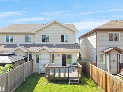 Rear exterior featuring a wooden deck with railing, sliding glass door access, and a fenced yard - 17127 126 Street Nw, Edmonton, AB - Outdoor