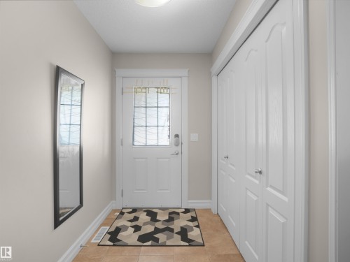 Entryway featuring a decorative glass panel door, light-toned wall paint, and bi-fold closet doors - 17127 126 Street Nw, Edmonton, AB - Indoor Photo Showing Other Room