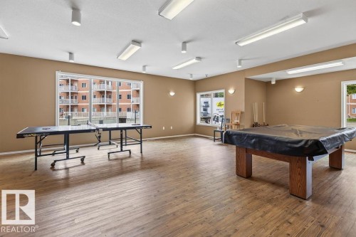 Open-concept recreation area featuring wood-finish flooring, multiple windows, and recessed lighting - #205 4304 139 Av Nw, Edmonton, AB - Indoor Photo Showing Other Room