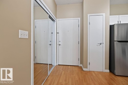 Wood-finish flooring with neutral wall paint - #205 4304 139 Av Nw, Edmonton, AB - Indoor Photo Showing Other Room