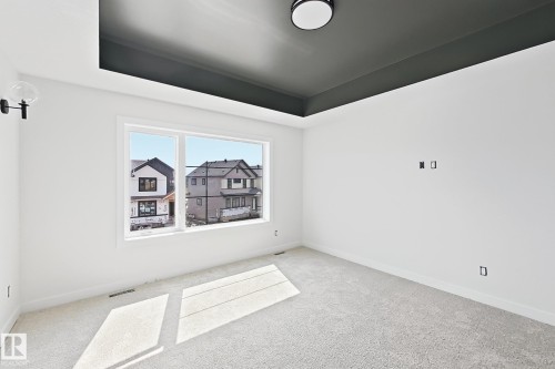 Recessed ceiling detail with a dark finish, flush-mount ceiling light, and wall-mounted sconce - 13118 186 Avenue Nw, Edmonton, AB - Indoor Photo Showing Other Room