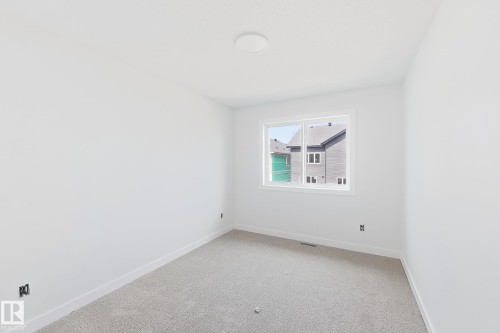 Window with white trim, wall-to-wall carpeting, white walls, and a ceiling-mounted light fixture - 13118 186 Avenue Nw, Edmonton, AB - Indoor Photo Showing Other Room