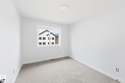 Neutral wall paint throughout, light-toned carpeting, ample natural light from a double-pane window, and a flush-mount ceiling light - 13118 186 Avenue Nw, Edmonton, AB - Indoor Photo Showing Other Room