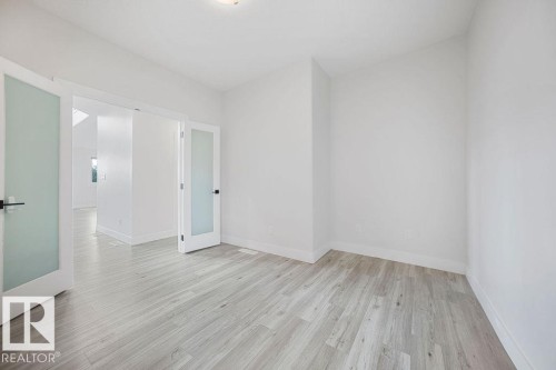 Wood-finish flooring, white walls, and bright overhead lighting - 9331 181 Avenue Nw, Edmonton, AB - Indoor Photo Showing Other Room
