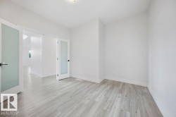 Wood-finish flooring, white walls, and bright overhead lighting - 